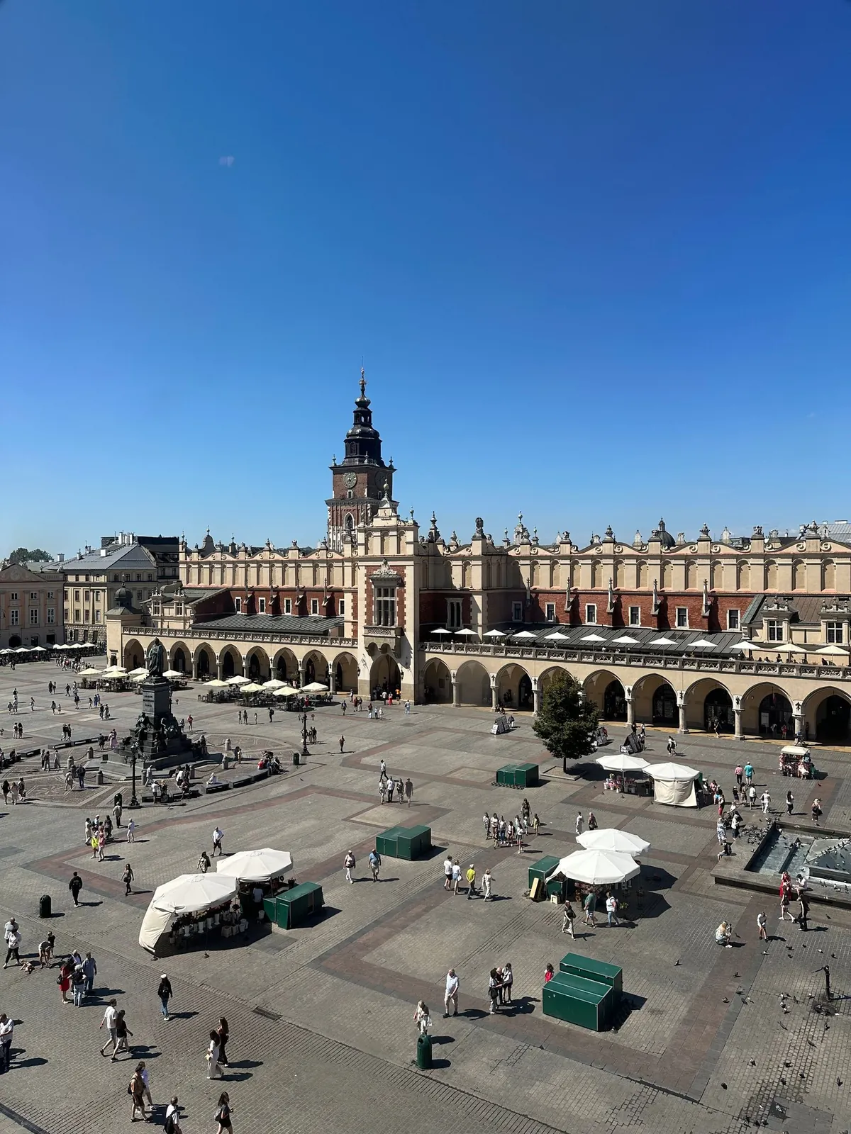 Kraków’s Cloth Hall and Main Market Square beneath a clear blue sky.